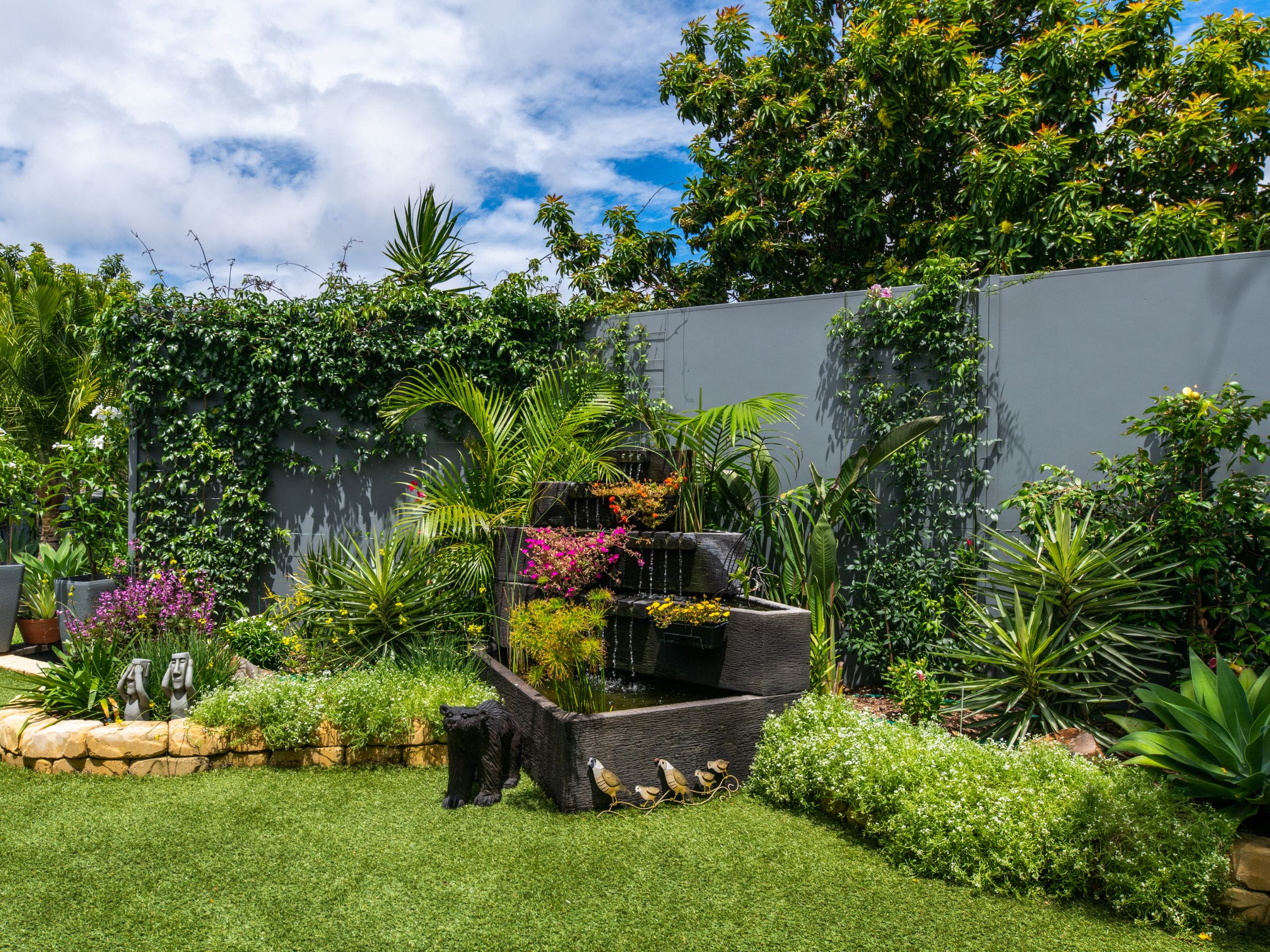 A whimsical garden provides a riot of colour with a grey SlimWall boundary fence making the perfect backdrop