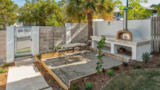 front yard outdoor entertaining area with pizza oven and ModularWalls privacy screen and front fence