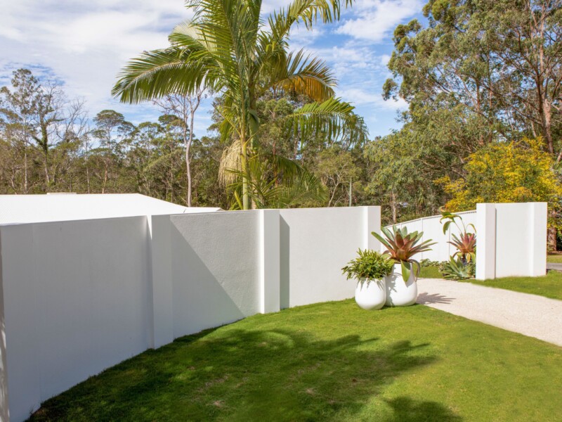 EstateWall front wall with flush wall capping and post tops with two large pot plants.