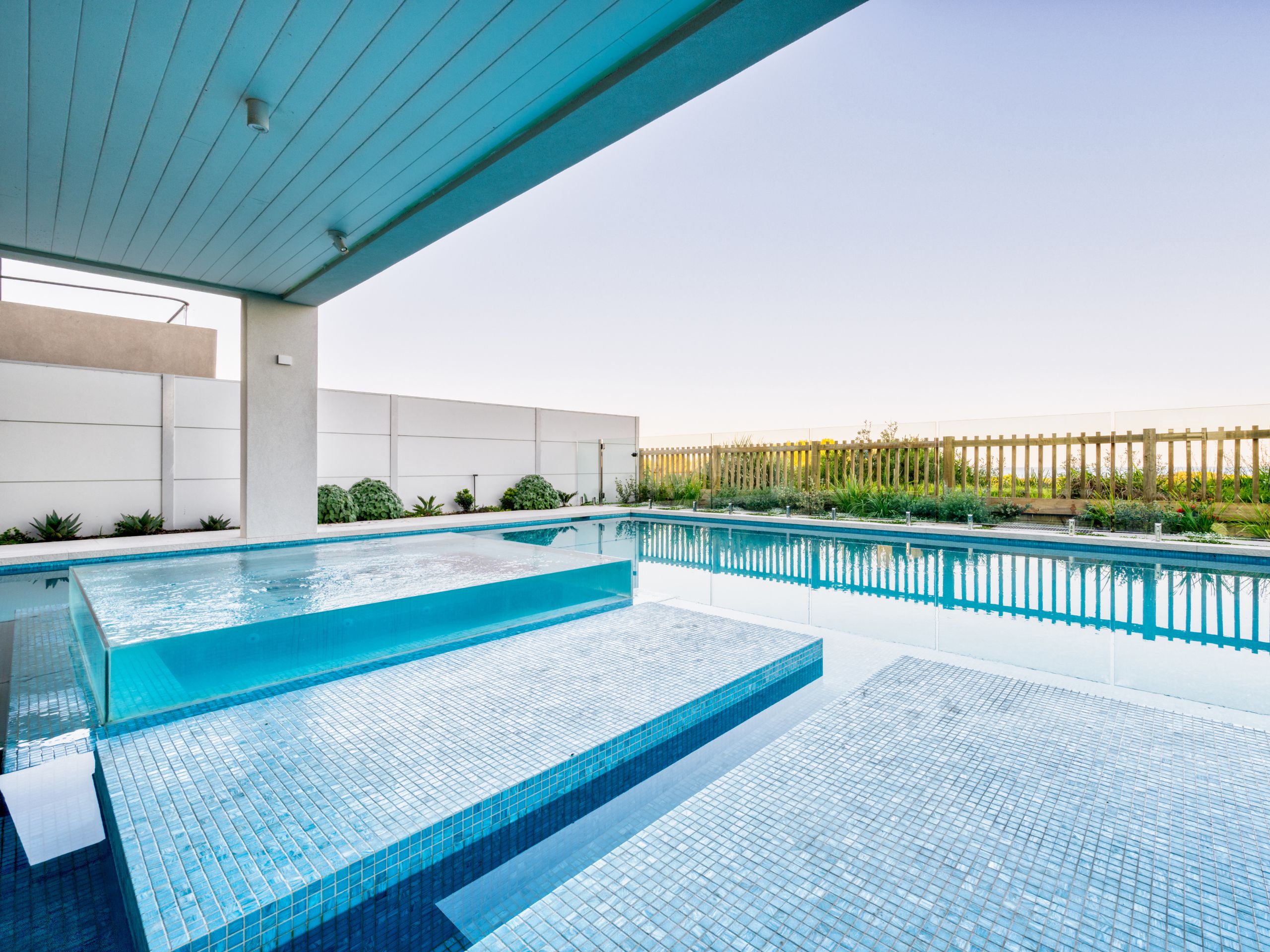 A luxurious pool area complete with inbuilt spa