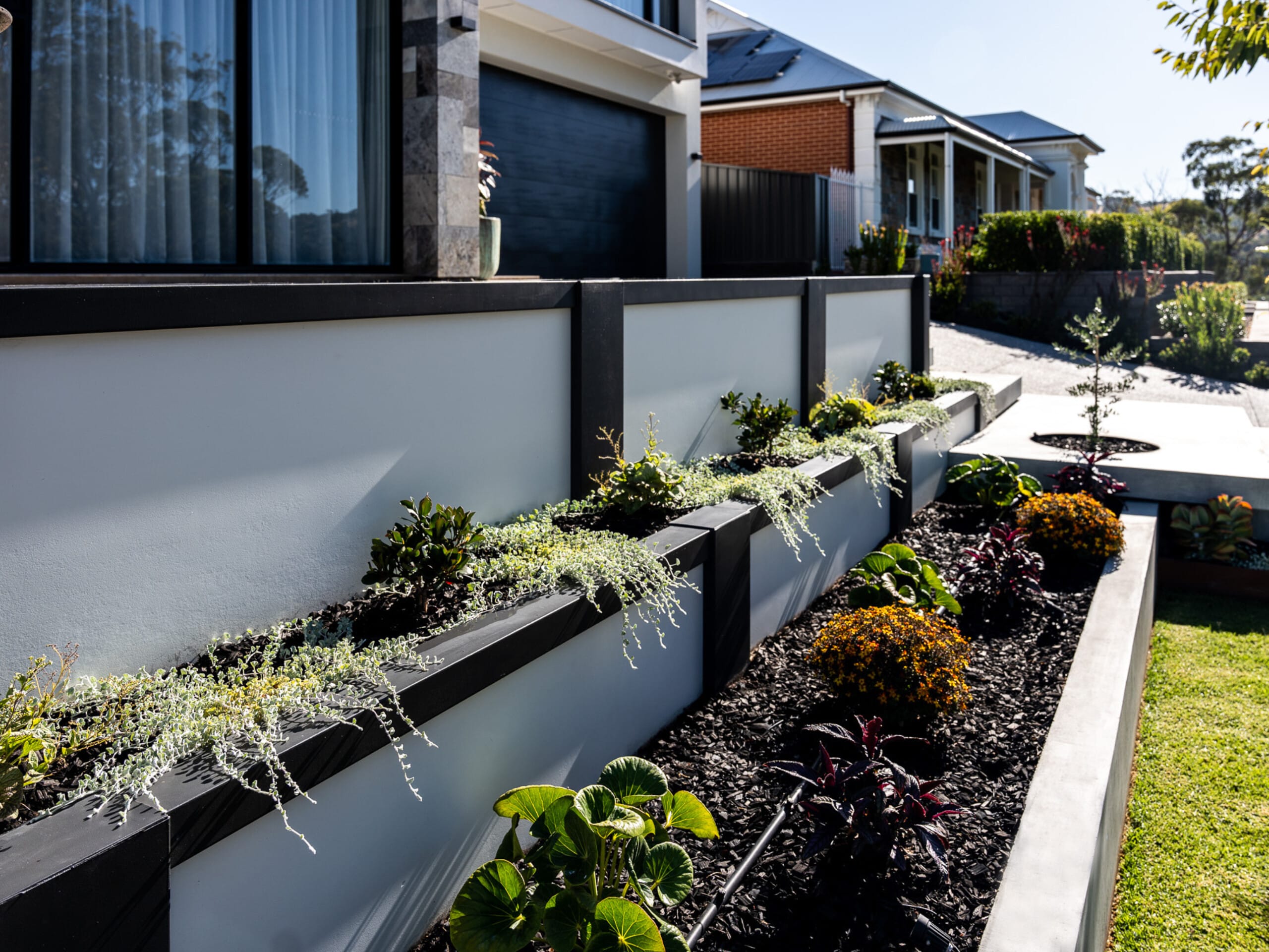 Create a stylish layered look by painting your composite retaining wall in a manner to suit your architectural style