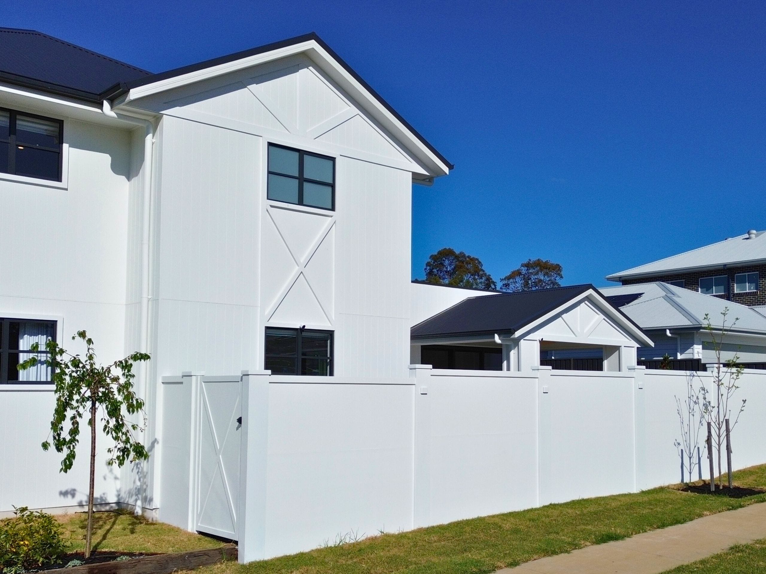Add custom timber or carriage-style details to gates and fence panels to tie the boundary to your home’s façade.